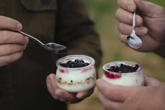 two yogurt parfaits with spoons about to dig into them