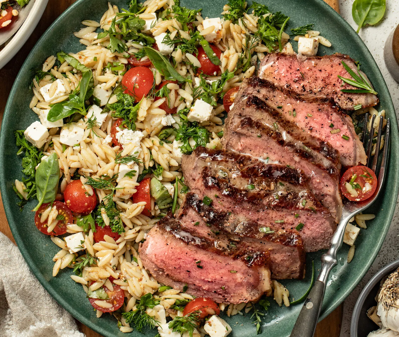 Garlic butter steak with tomato orzo salad