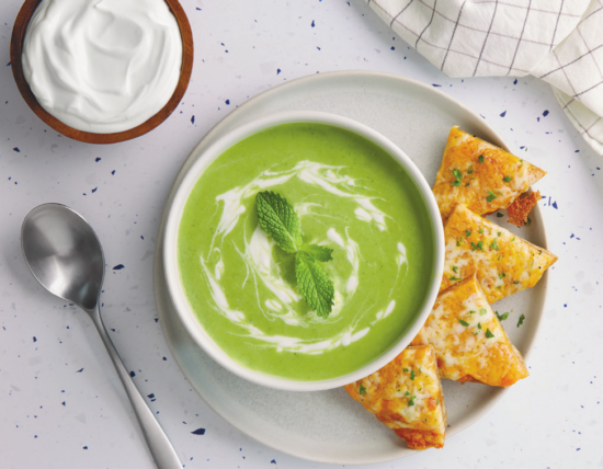 bowl of spring soup with cheesy pitas with a side of sour cream