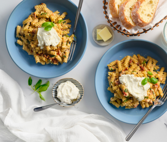 bowls of fusilli pasta topped with whipped ricotta